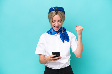 Airplane blonde stewardess woman isolated on blue background surprised and sending a message