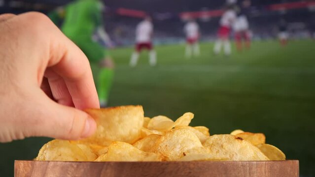 Couple Watching football match on tv and eating snack potatoes chips