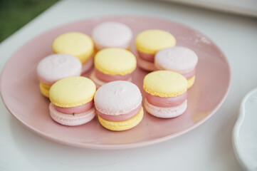 Baby birthday. French macaroons on a cake stand .Candy bar with macaron, cakes, cheesecakes, cake pops.