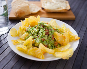 traditional soft avocado salad. Guacamole with chips on a plate