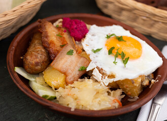 Scrambled eggs with fried bacon and potatoes served on plate