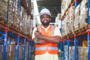 Obraz na płótnie Canvas African American male worker in helmet wearing chef's suit holding walkie talkie crossing arms success ready to deliver goods in warehouse