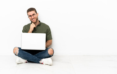 Young man sitting on the floor laughing