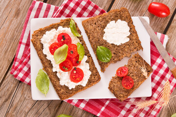 Rye bread with cottage cheese, basil and tomato.