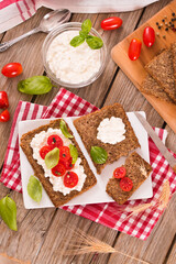 Rye bread with cottage cheese, basil and tomato.