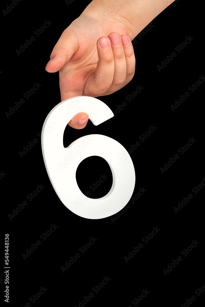 Poster number six in hand isolated on black background. number six in a child's hand holding on a black bac