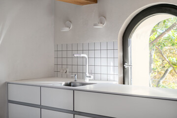 light kitchen with furniture, faucet, sink and window