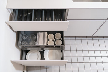 modern cupboard with drawers for storage cutlery and dishware at kitchen