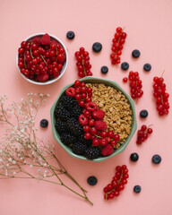 muesli with berries on a pink background