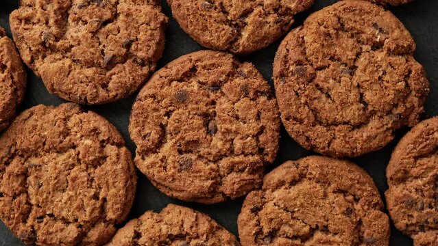 Fresh oatmeal cookies rotating. Food concept. Homemade cookies with chocolate. Stack of whole meal cookies. Top view. Close-up in 4K, UHD