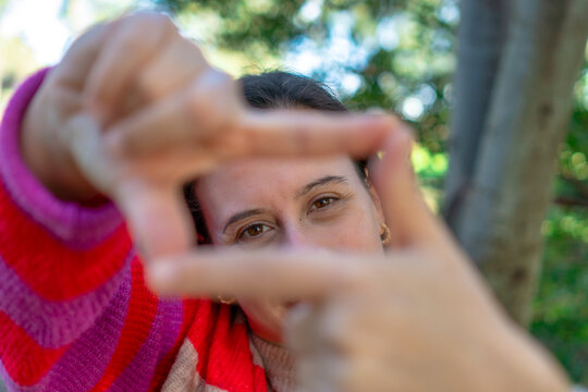 close-up of woman with fingers in square shape