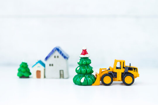 Front loader truck moving Christmas tree over blurred background, Festive season time