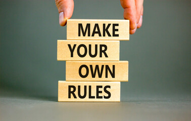 Make your own rules symbol. Concept words Make your own rules on wooden cubes. Beautiful grey table grey background. Businessman hand. Business motivational make your own rules concept. Copy space