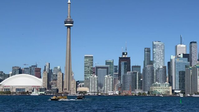 Toronto, Ontario, Canada - Oct. 2022 - video view of Toronto downtown with Skyline and the CN Tower with hight of 553.3 meters - boats crossing the Lake to Toronto Island