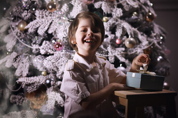 Child in smart clothes in front of the Christmas tree. New Years Eve. Waiting for the new year.