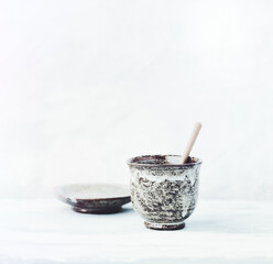 Traditional, handcrafted ceramic on bright wooden background. Soft focus. Copy space.	