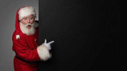 Santa Claus pointing black billboard - 549463382