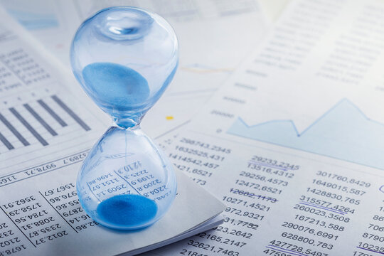Best time for investment. Hourglass, financial charts and calculator.