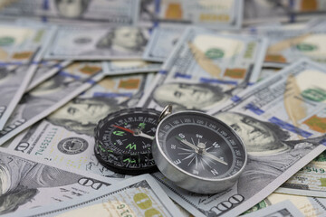 Two navigational compasses against the background of American dollars. Business path concept