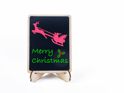 small black chalk board with happy Christmas message and flying Father Christmas graphic on a white background .