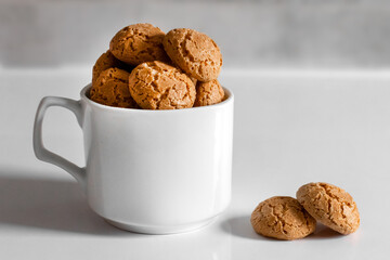 homemade cracked amaretti cookies in a white coffee cup
