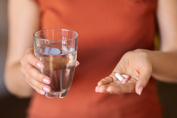 Unrecognizable Woman Holding Glass Of Water And Pile Of Pills In Hand