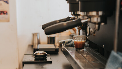 Making fresh coffee from espresso machine. preparing hot espresso coffee by automatic coffee machine in counter coffee shop.