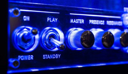 Music amplifier control panel audio sound level knobs detail blue neon light