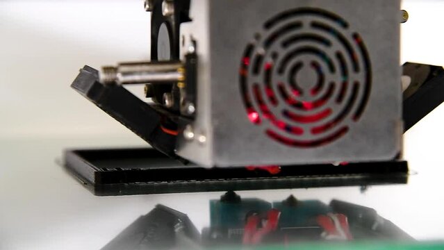 3D printer close-up printing the product. The printer elements are moving