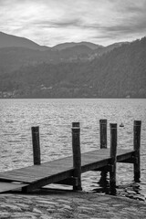Pier at the sunset in the Orta Lake, small glacier lake of Northern Italy (Piedmont, Novara Province) UNESCO site.