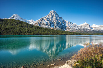 Panorama view of the rocky mountains in Canada with reflection in the lake