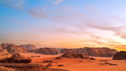 Fototapeta na wymiar Wadi Rum, Jordan. A beautiful vibrant blue and orange sunset, Arabian desert, a dystopian martian landscape with unique rock formations and dunes. Backdrop for graphic resource or copy space no people