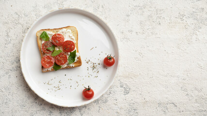 toasts with feta cheese and cherry tomatoes on a white dish, close-up, healthy snack