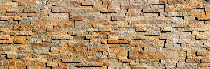 Decorative stone wall background pattern. Brown modern seamless brick wall luxury texture close up