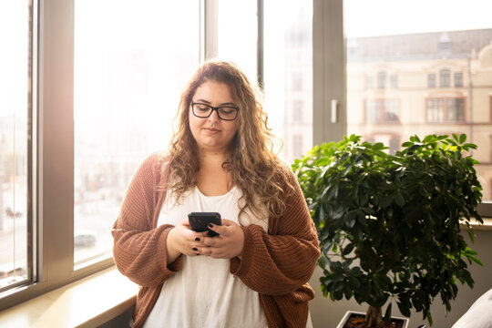 Portrait of a woman, using phone in the office