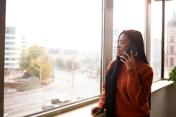 African, young girl in the office in front of the window 