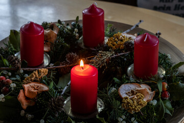 Adventkranz mit leuchtender Kerze