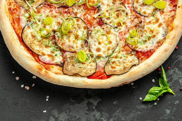 vegan pizza with eggplant, tomatoes and leeks on a dark background, banner, menu, recipe place for text, top view