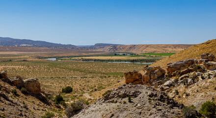 farm field in the Utah desert in the summer with a river near the foreground