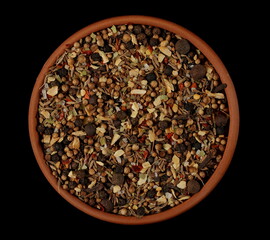 Spice blend, garam masala, mix black pepper, coriander, cumin, garlic granules, allspice, sea ​​salt, ground chili peppers, cinnamon, cloves grain, chopped ginger, bay leaves in bowl isolated on black