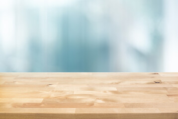 Selective focus.Top of wood  table with blur window glass  background.