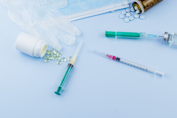 white medical protective glove, medical mask, syringe with needle, vaccination, vial and pills....