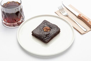 Isolated shot of a plate of brownie with a drink and spoon on the side