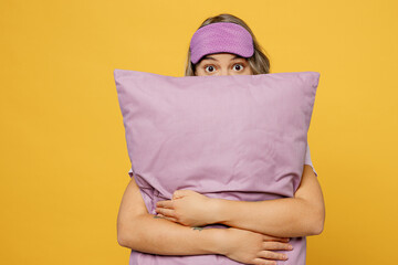 Worry scared young woman in pajamas home wear sleep eye mask hold purple sheet pillow spending time...
