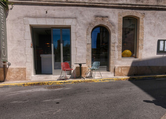 Facade of a house in Arles, France. Cafe facade with two chairs and a table.