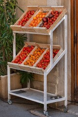 Red and yellow tomatoes stacked in crates in Arles, France. Tomatoes in boxes at the store. Summer harvest in Provence.