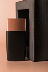 Bottle for cosmetics against the background of black packaging made of corrugated eco paper. Design, branding.