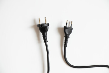 Two black cables with plugs on a white background, cable