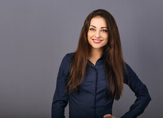 Obraz premium Beautiful confident thinking smiling business woman in blue formal shirt on grey background with empty copy space for text. Closeup