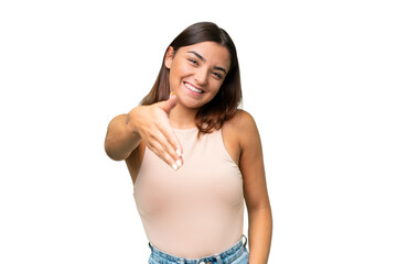 Fototapeta premium Young caucasian woman isolated on green chroma background shaking hands for closing a good deal